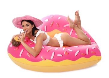 Beautiful young woman in stylish bikini with cocktail and inflatable ring on white background