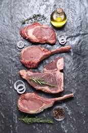 Fresh raw beef cuts and different spices on grey textured table, flat lay