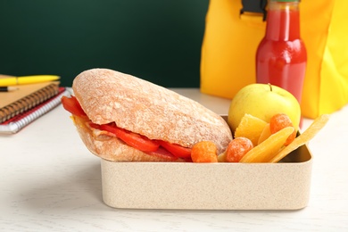 Lunch box with appetizing food on table