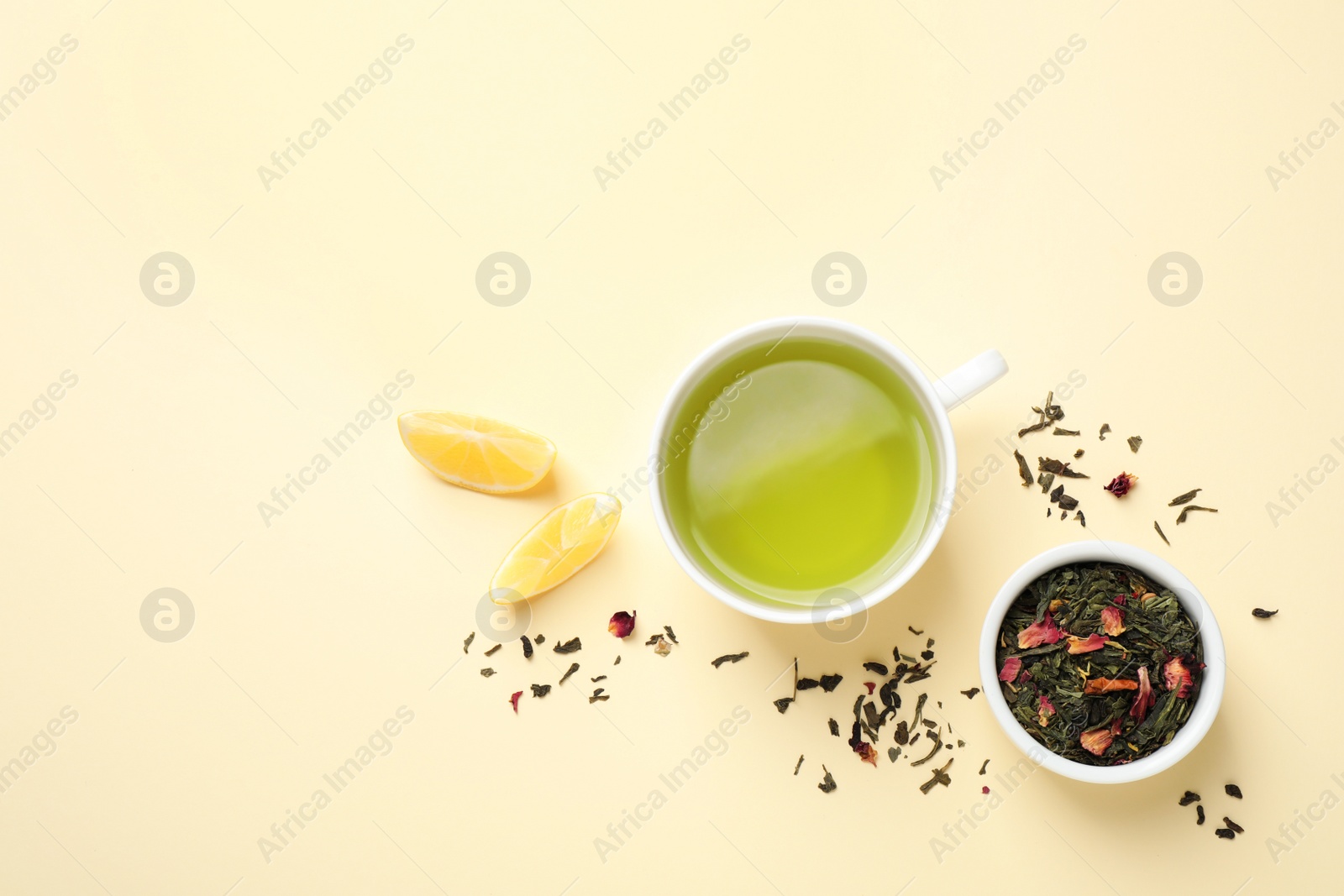 Photo of Flat lay composition with green tea and lemon on beige background. Space for text