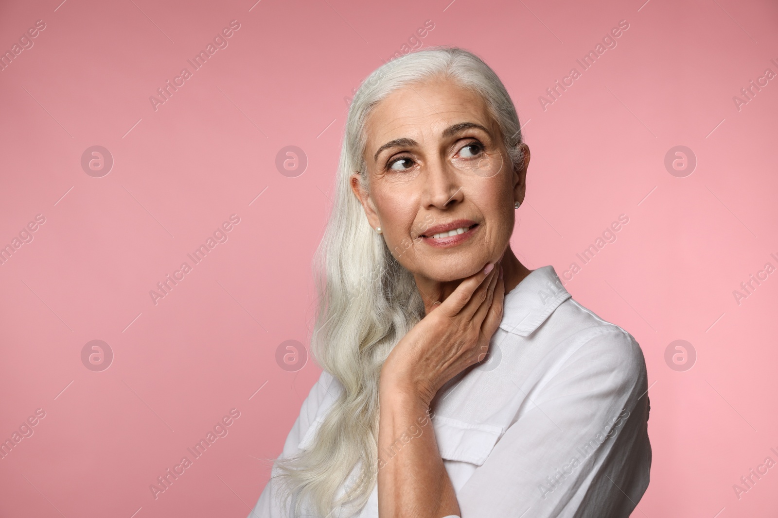 Photo of Portrait of beautiful mature woman on pink background, space for text