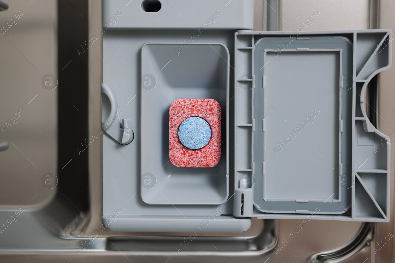 Photo of Open dishwasher door with detergent tablet, top view