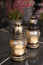 Photo of Grave lanterns on black tiled surface at cemetery