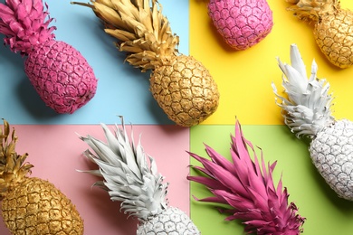 Photo of Many white, pink and golden pineapples on color background, flat lay. Creative concept