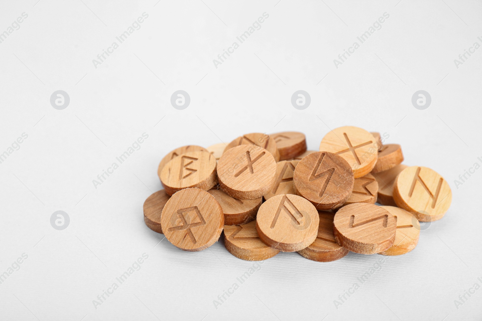 Photo of Pile of wooden runes on white background