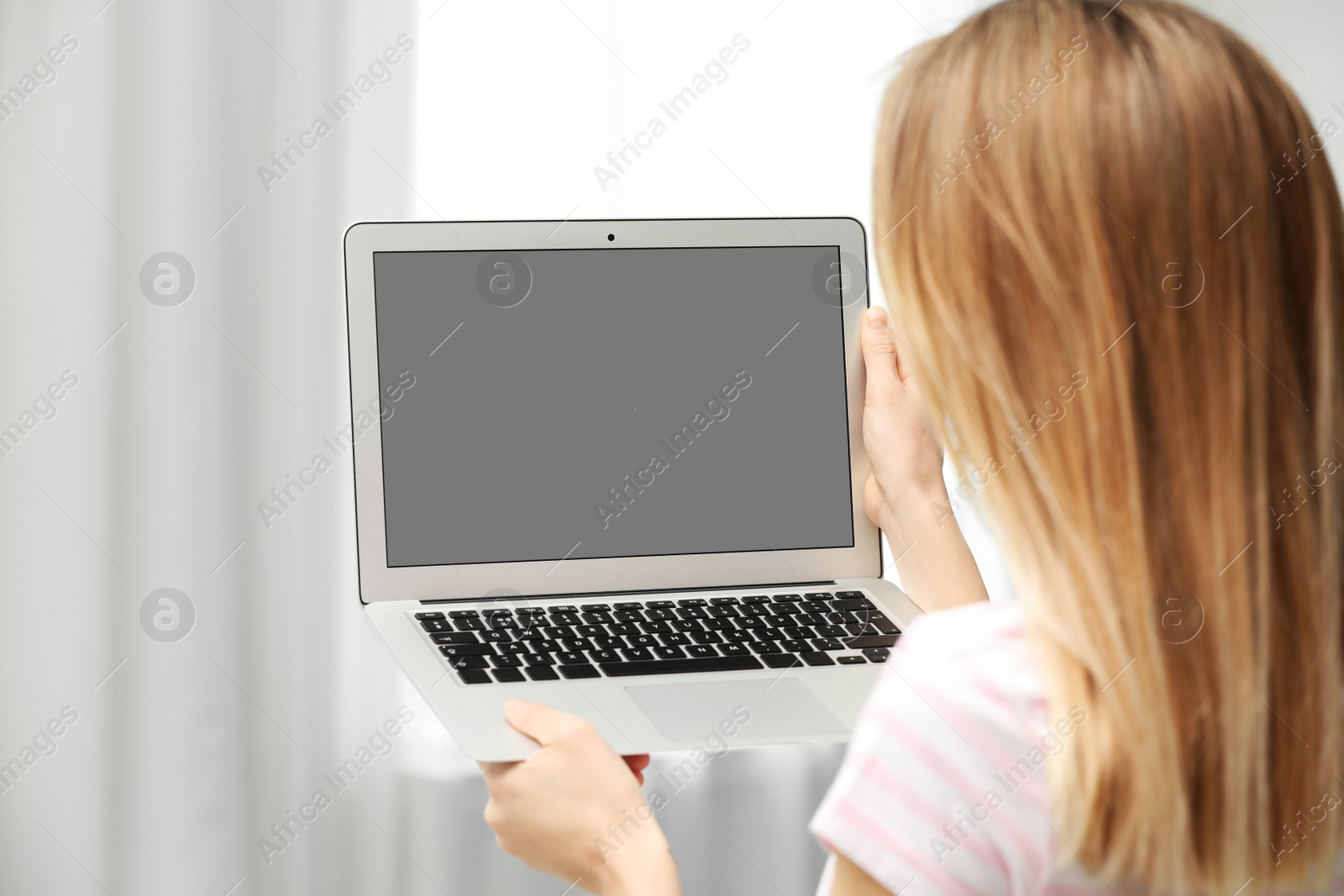 Photo of Young woman using video chat on laptop indoors, closeup. Space for design