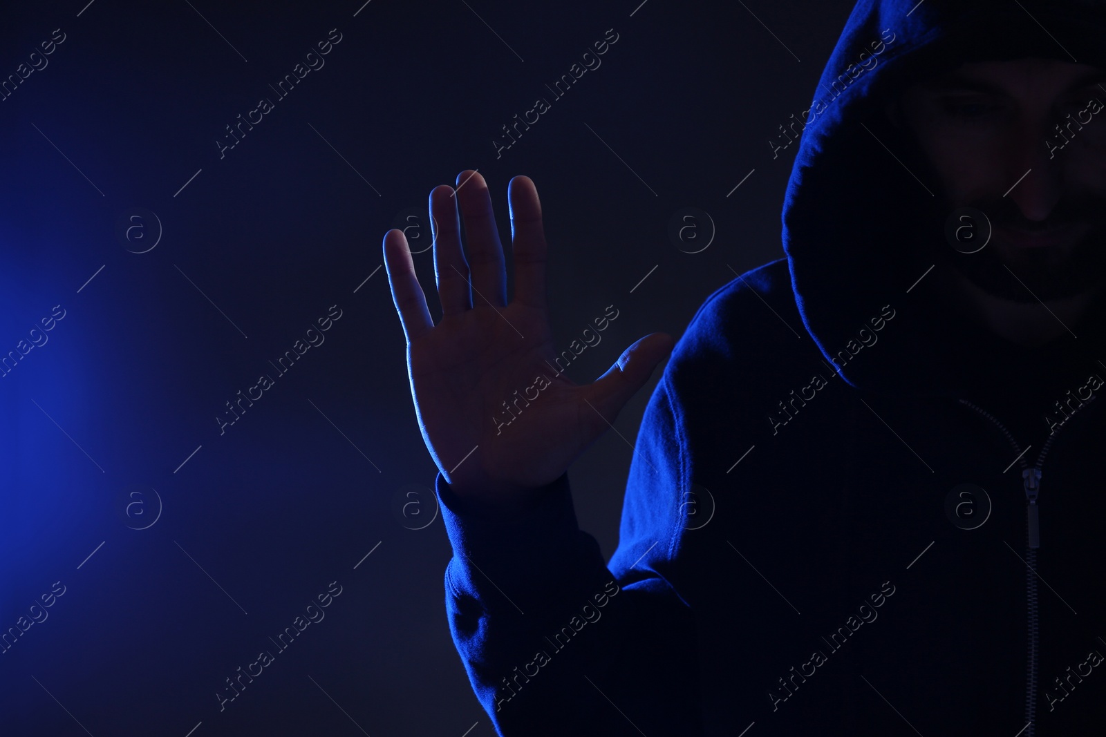 Photo of Man in hood on dark background. Cyber crime