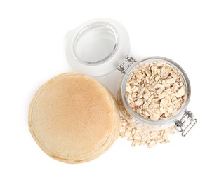 Photo of Tasty oatmeal pancakes and flakes on white background, top view