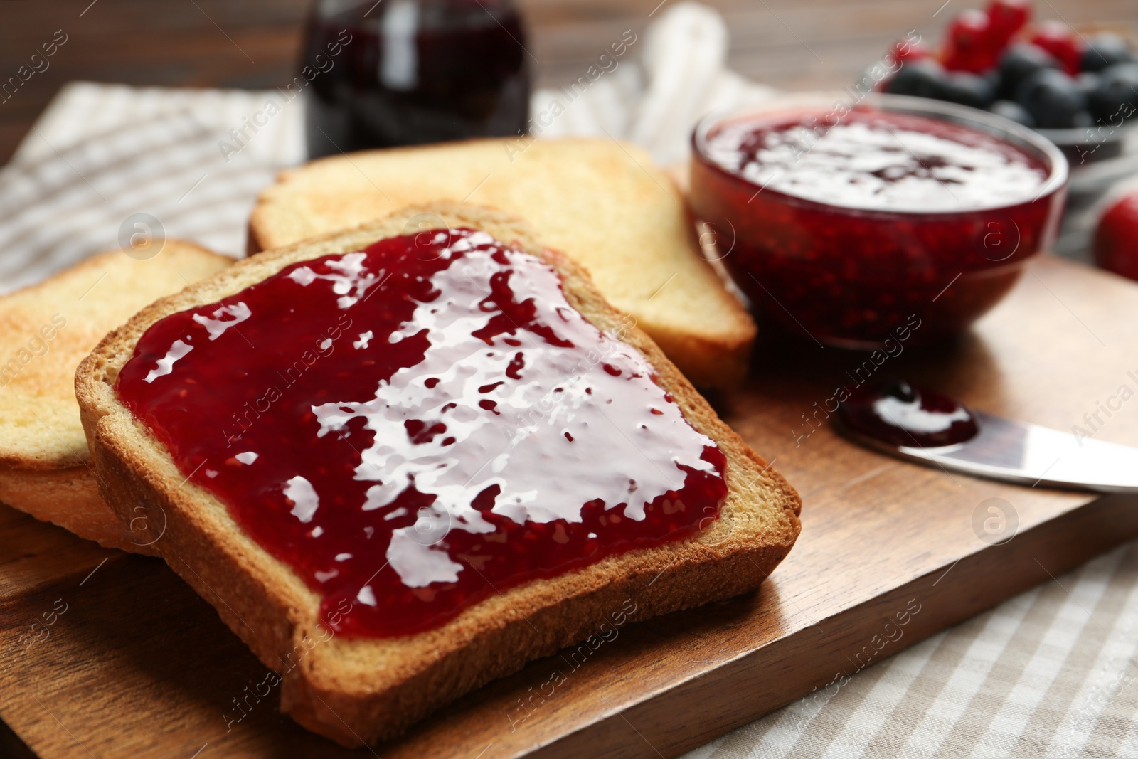 Photo of Delicious toasts with jam served on table, closeup