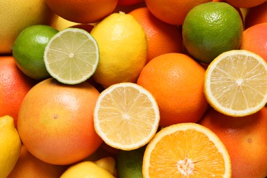 Different fresh citrus fruits as background, top view