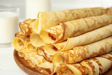 Fresh thin pancakes on white table, closeup