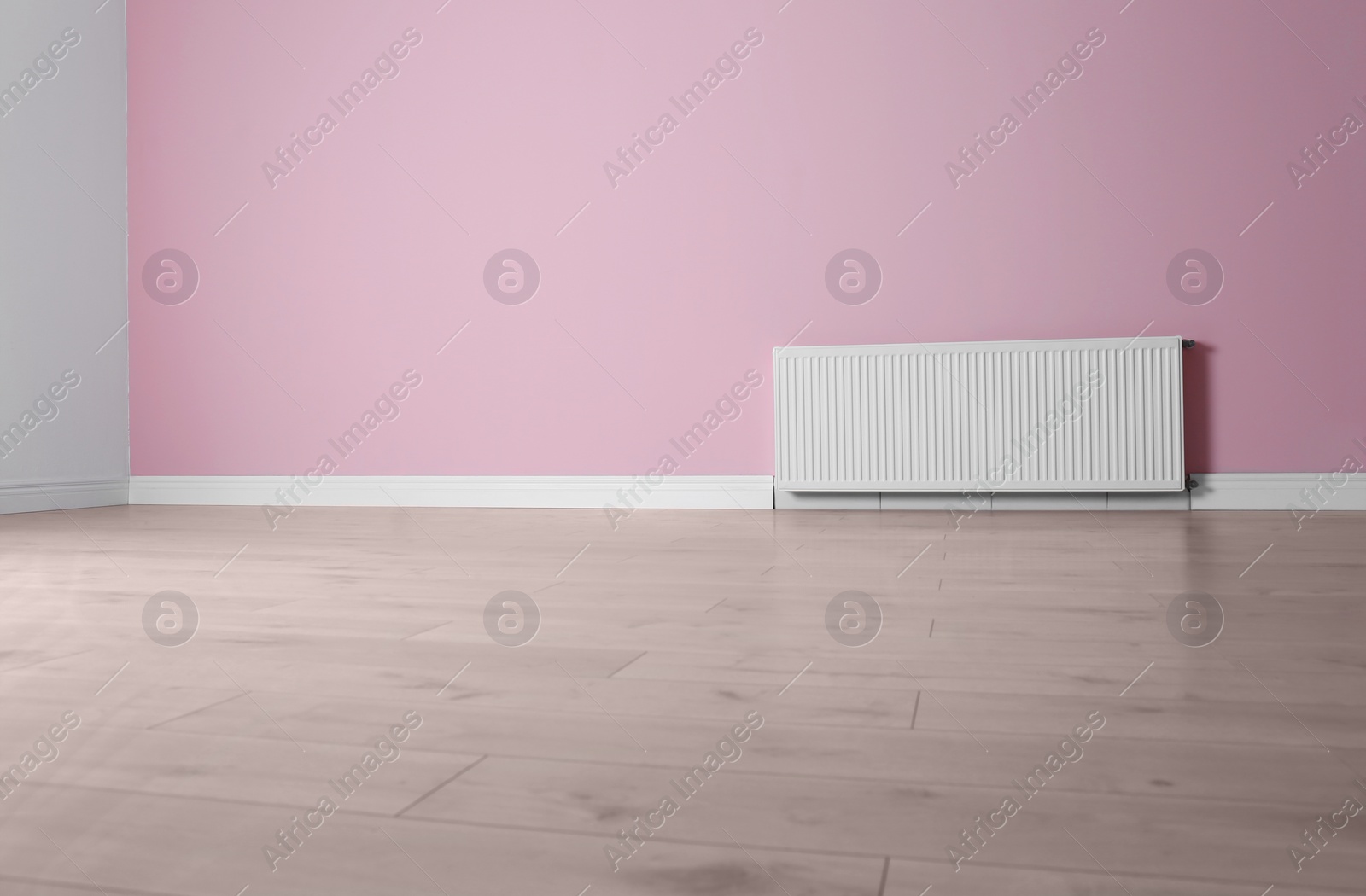 Photo of Modern radiator on color wall with space for text. Central heating system