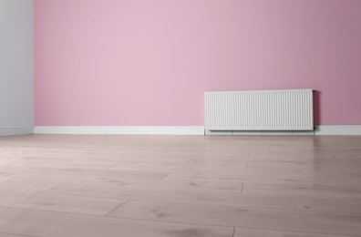Modern radiator on color wall with space for text. Central heating system