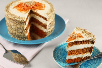 Photo of Tasty cut carrot cake on served light table