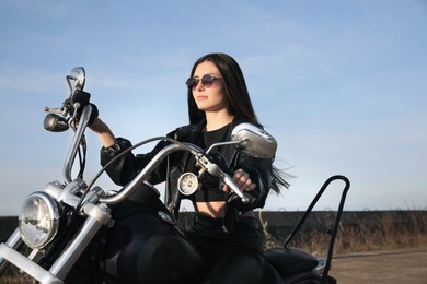 Photo of Beautiful young woman riding motorcycle on sunny day