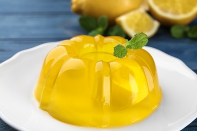 Photo of Tasty lemon jelly with mint on plate, closeup
