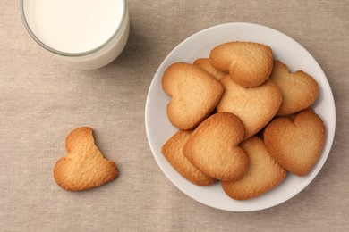 Photo of Heart shaped Danish butter cookies and milk on table, flat lay