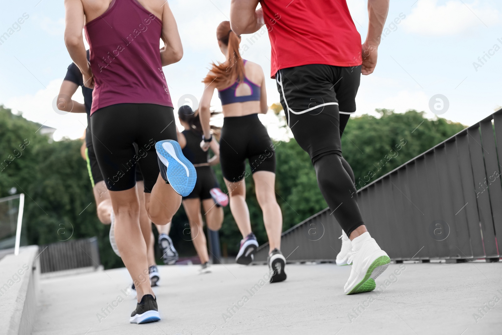 Photo of Group of people running outdoors, back view