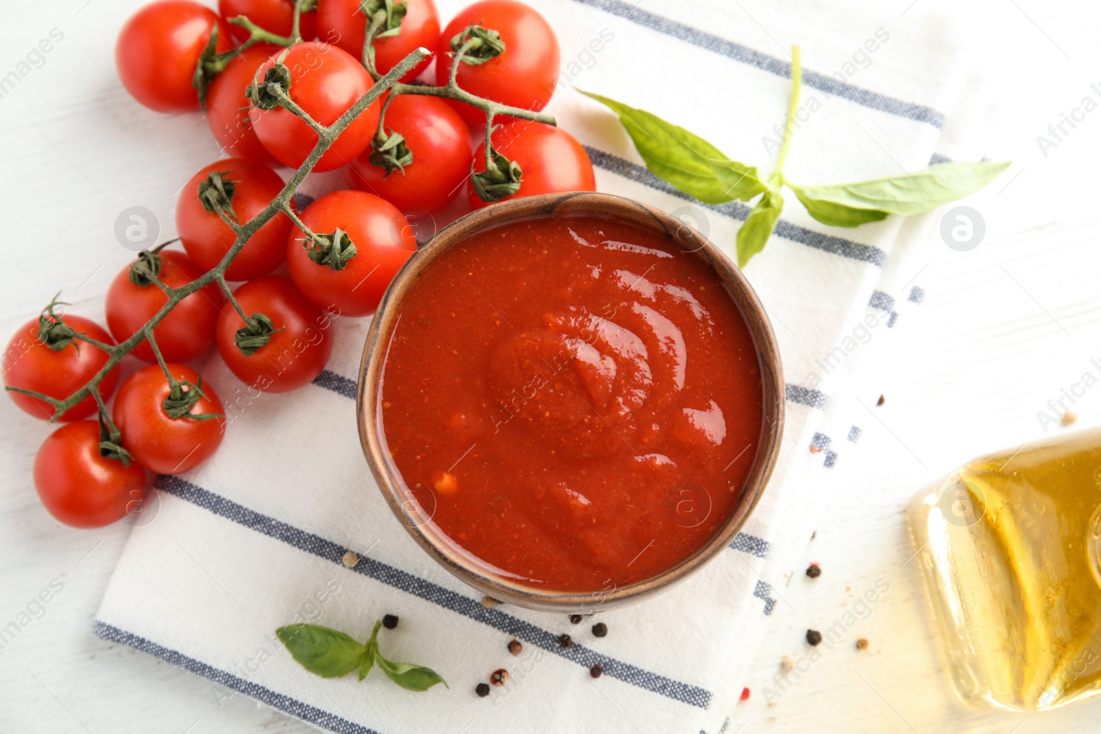 Photo of Flat lay composition with bowl of sauce and tomatoes on white table