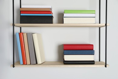 Shelves with many hardcover books on white wall