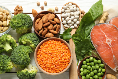 Products rich in protein on white wooden table, flat lay