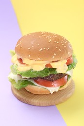 Photo of Burger with delicious patty on color background