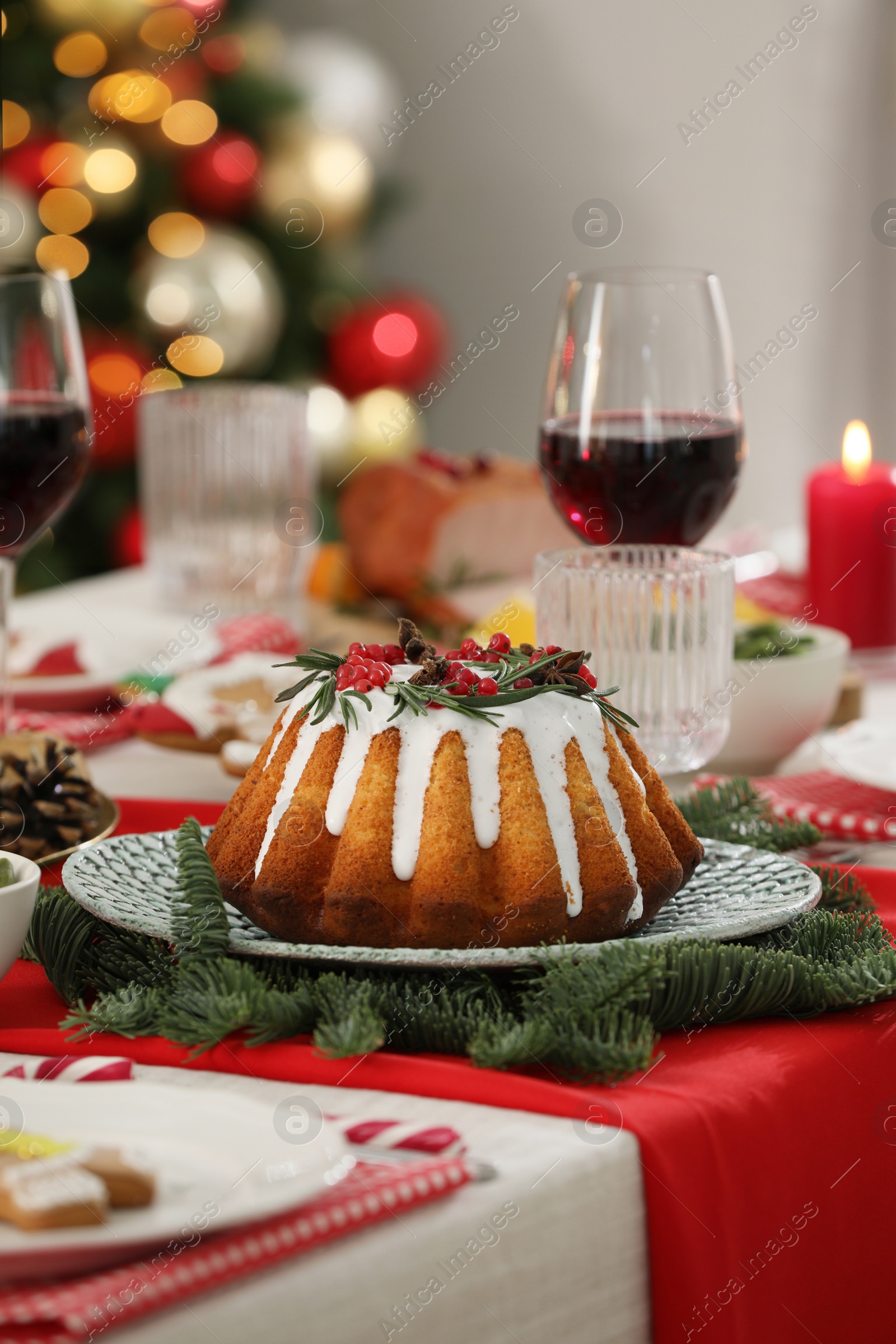 Photo of Festive dinner with delicious cake served on table indoors. Christmas Eve celebration