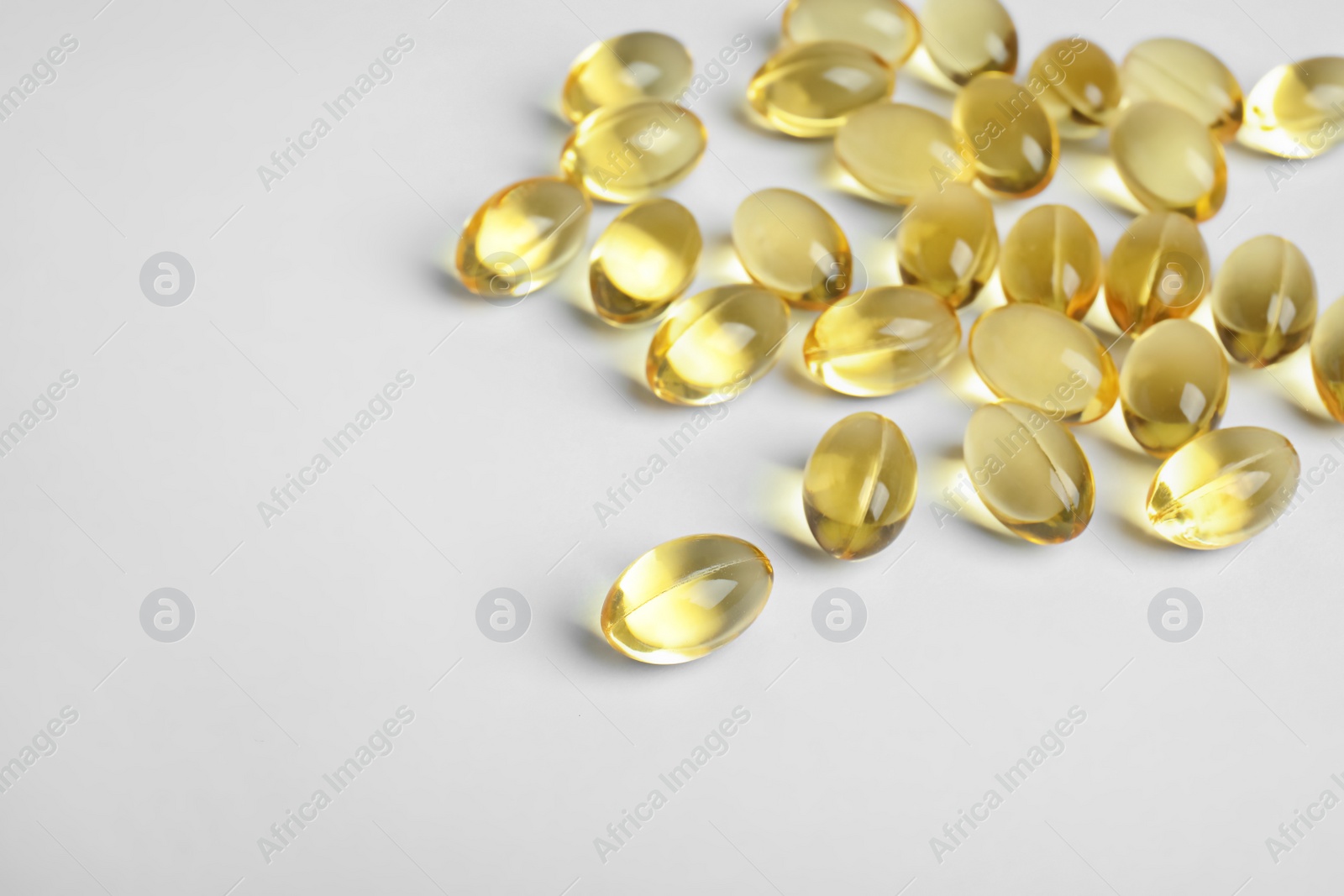 Photo of Cod liver oil pills on white background