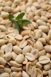 Photo of Many fresh peeled peanuts and leaves as background, closeup