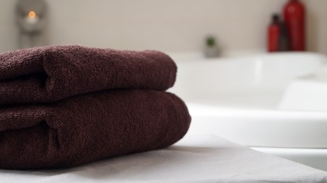 Photo of Stacked bath towels on table in bathroom, closeup. Space for text