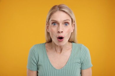 Photo of Portrait of surprised woman on yellow background