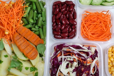 Set of plastic containers with fresh food on white wooden table, flat lay