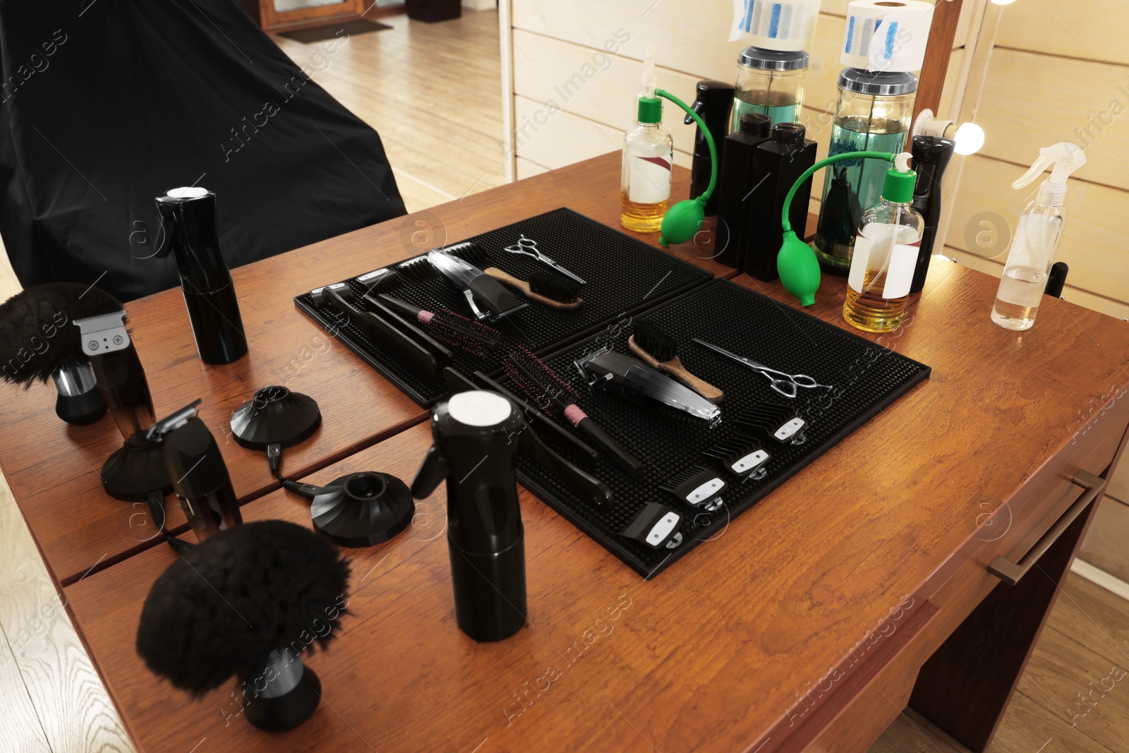Photo of Set of hairdressing tools on wooden table in salon