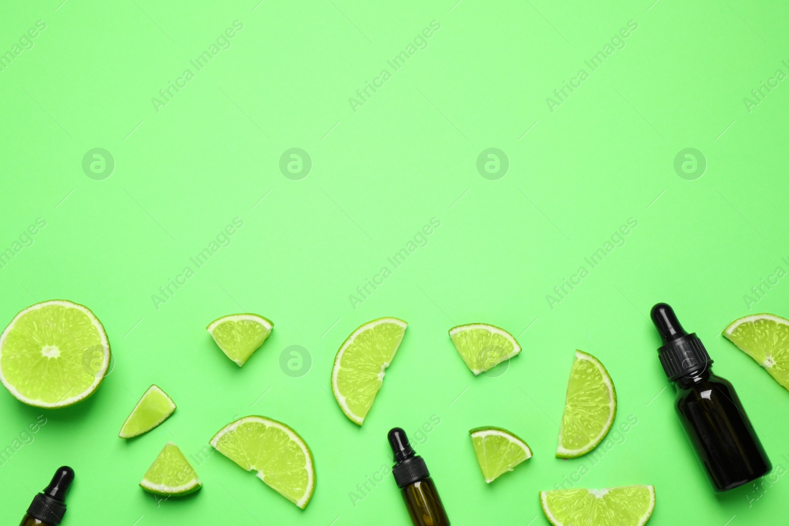 Photo of Flat lay composition with lime essential oil on green background. Space for text