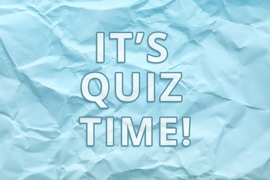 Image of Phrase IT'S QUIZ TIME on crumpled light blue paper 