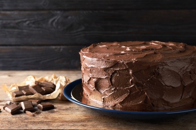 Plate with tasty homemade chocolate cake on wooden table