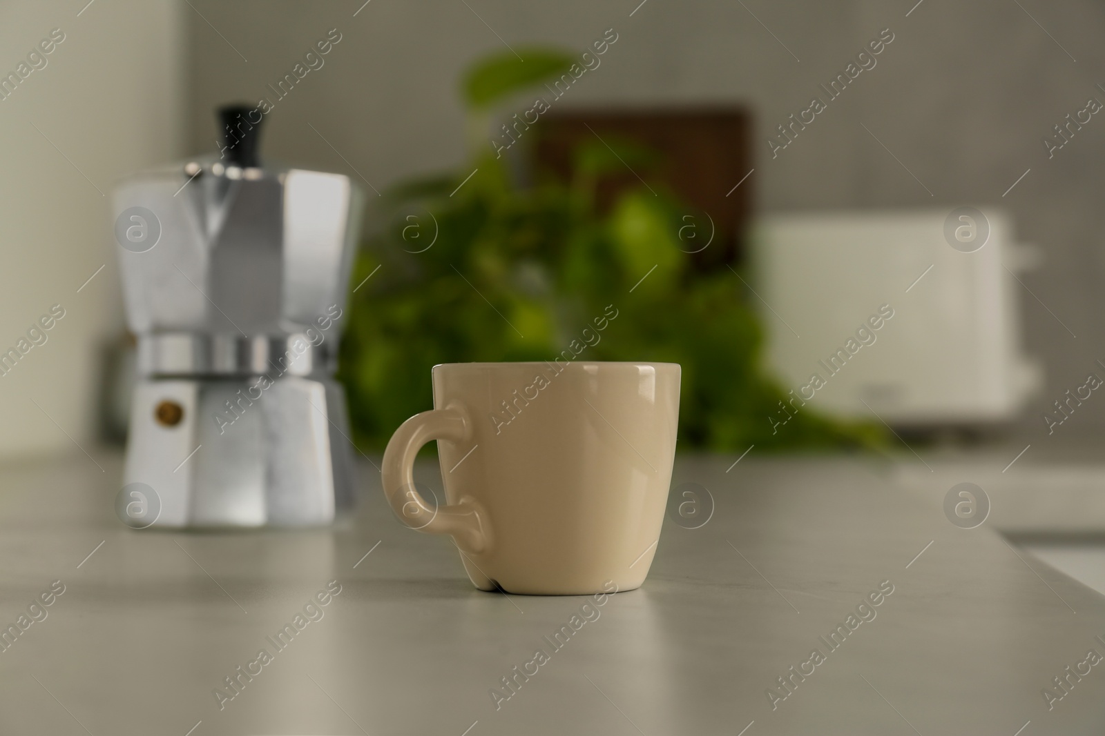 Photo of One ceramic cup on light grey countertop in kitchen