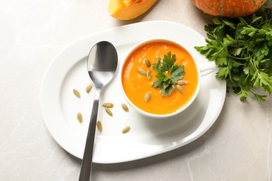 Photo of Flat lay composition with bowl of pumpkin soup on table