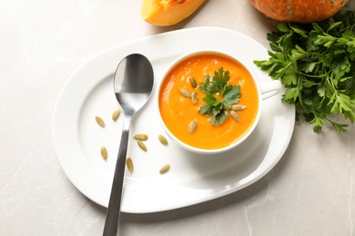 Flat lay composition with bowl of pumpkin soup on table