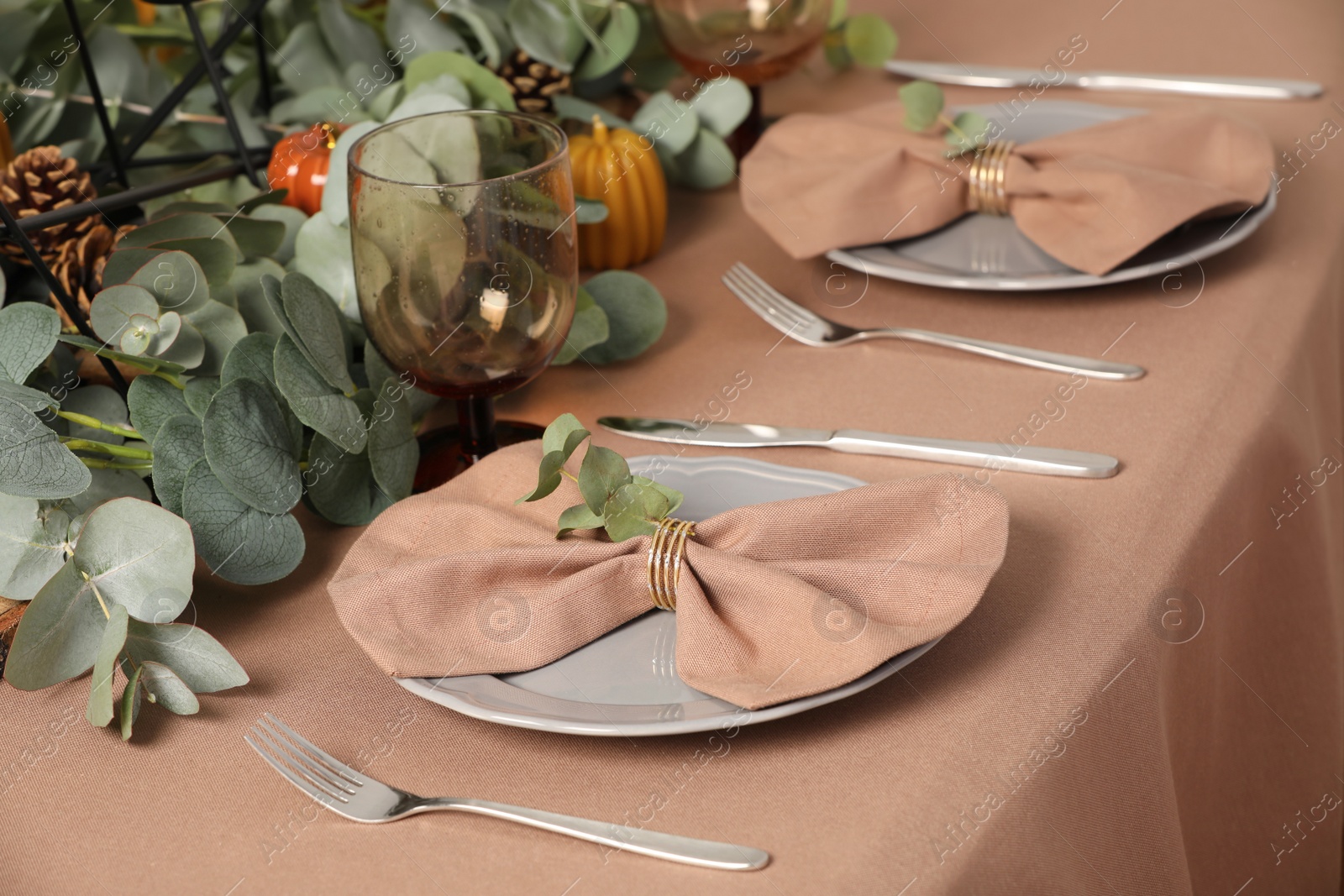 Photo of Autumn table setting with eucalyptus branches and pumpkins