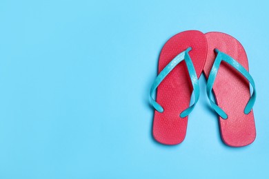 Photo of Stylish flip flops on light blue background, flat lay. Space for text