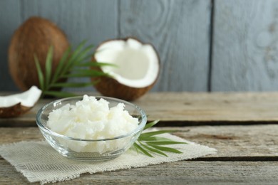 Photo of Organic coconut cooking oil on wooden table. Space for text