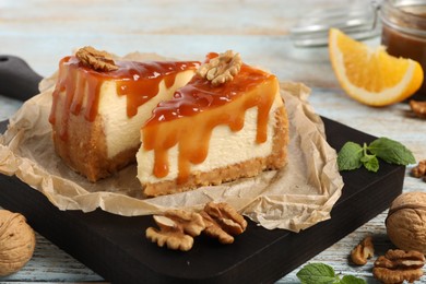 Photo of Pieces of delicious caramel cheesecake with walnuts served on table, closeup