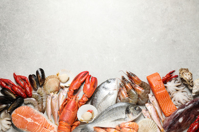 Fresh fish and seafood on marble table, flat lay. Space for text