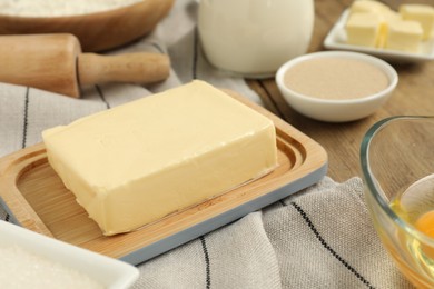 Photo of Fresh butter among other products on wooden table, closeup