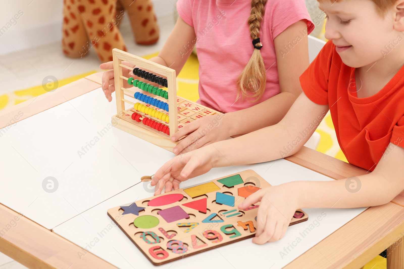 Photo of Children playing with different math game kits at desk indoors, closeup. Study mathematics with pleasure