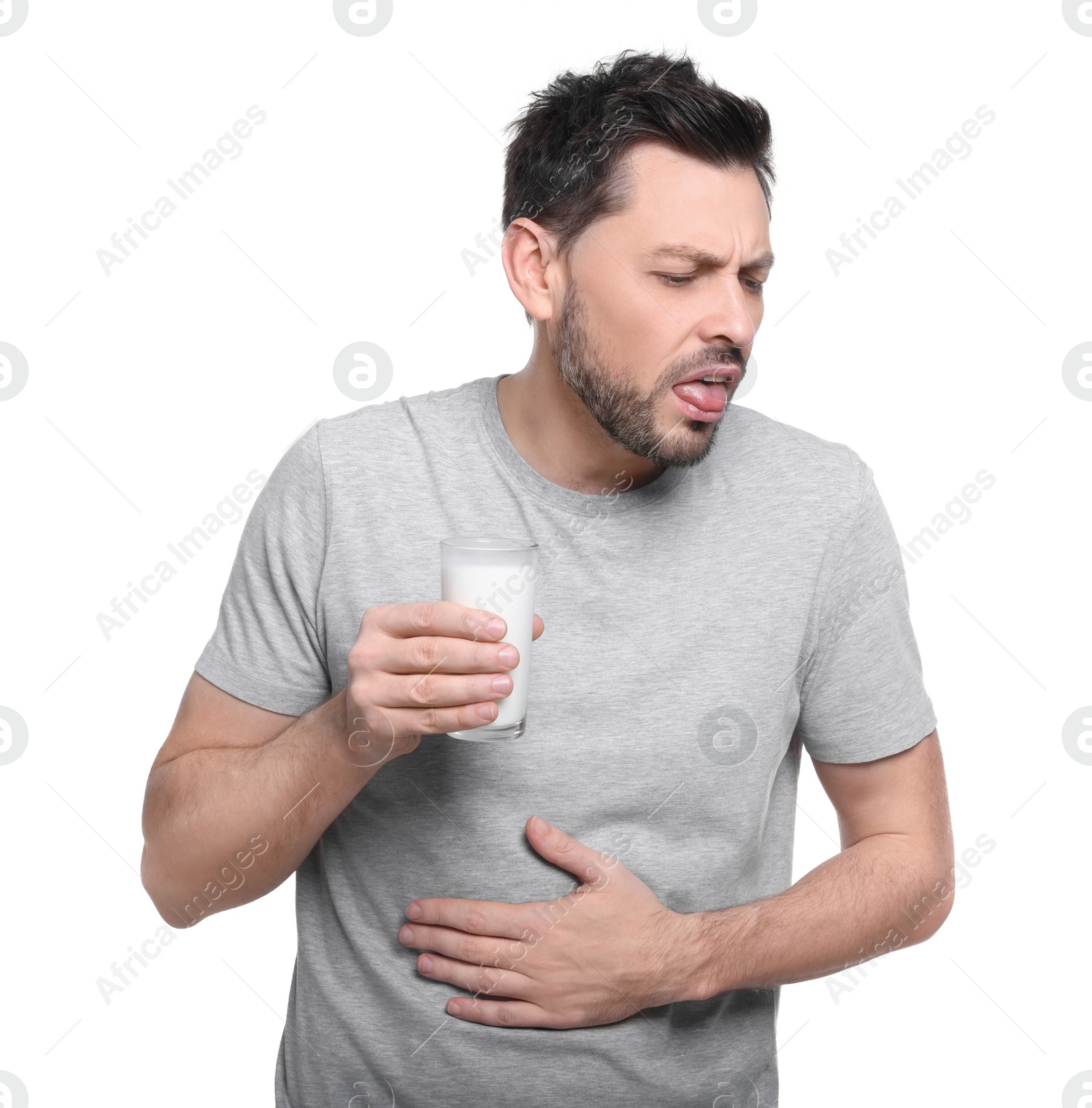 Photo of Man with glass of milk suffering from lactose intolerance on white background