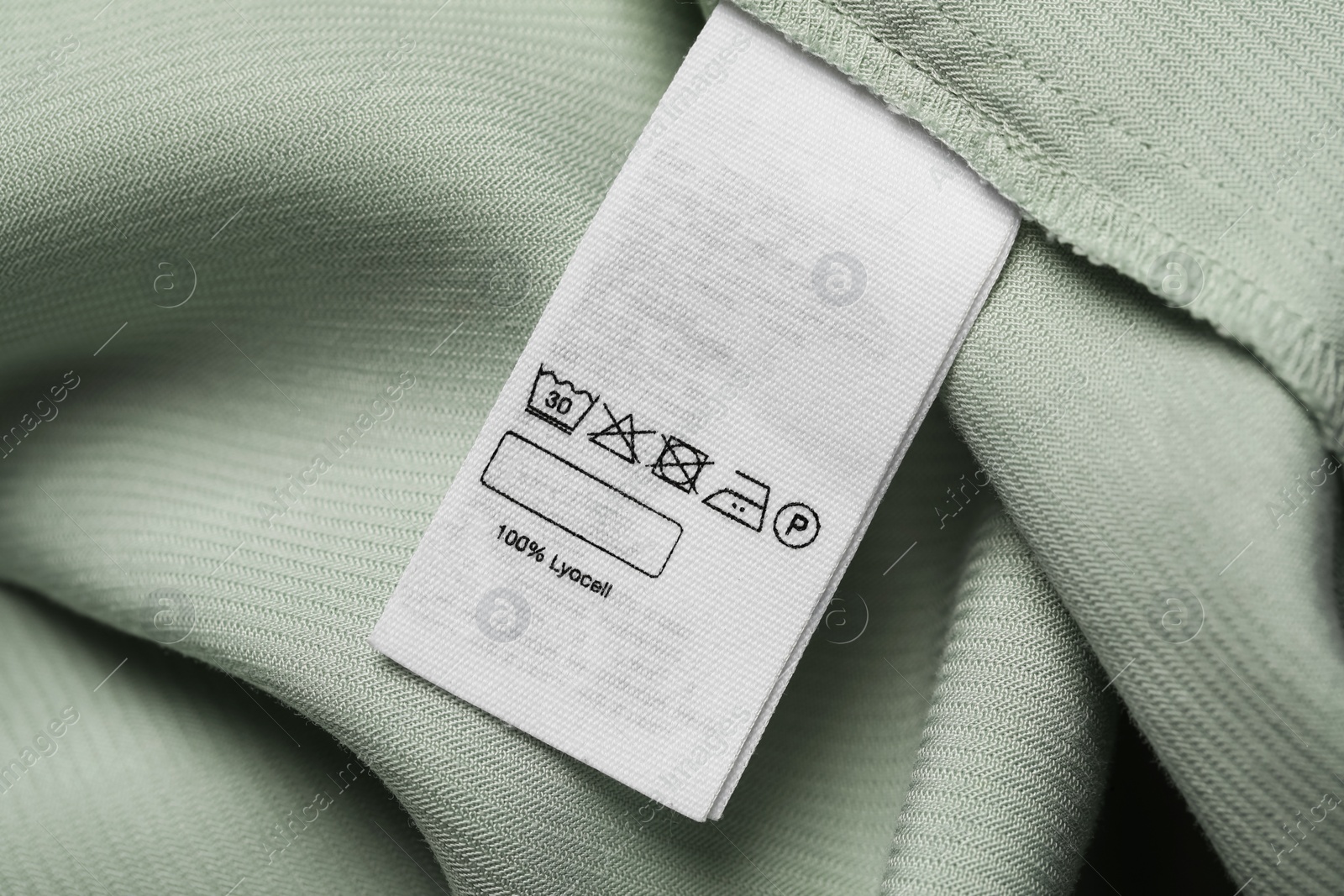 Photo of Clothing label on light green garment, top view