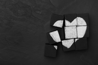 Photo of Heart drawn on black cubes, flat lay with space for text. Composition symbolizing problems in relationship