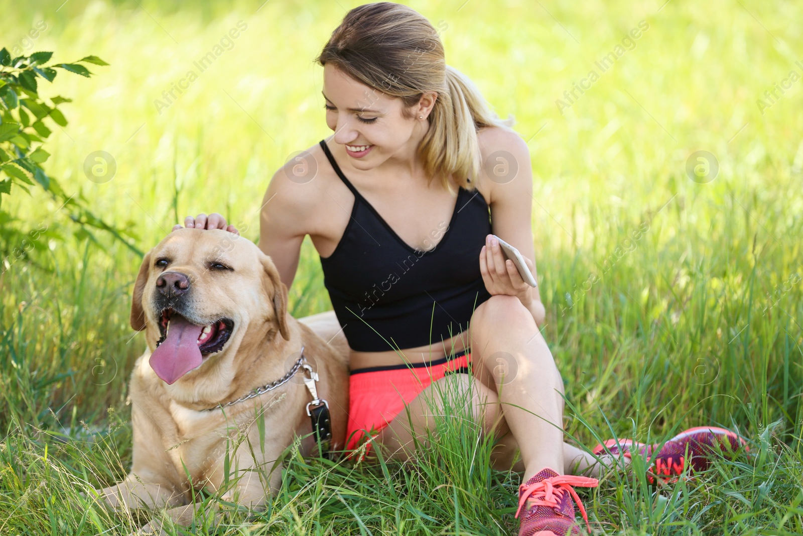 Photo of Young woman and her dog spending time together outdoors. Pet care